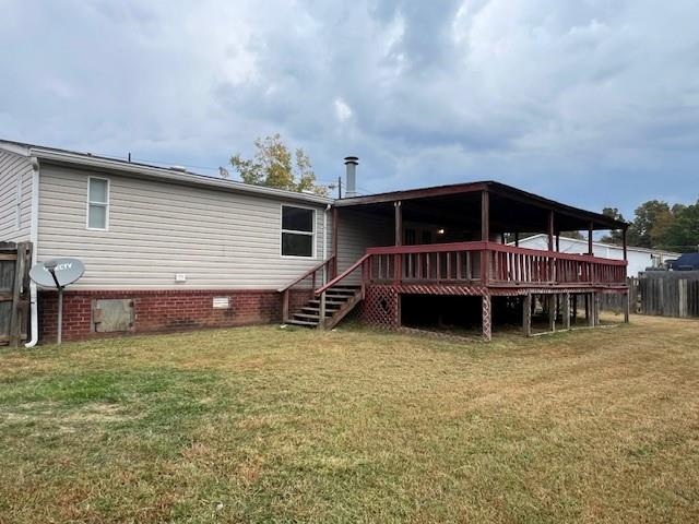 Back of house featuring a deck and a lawn