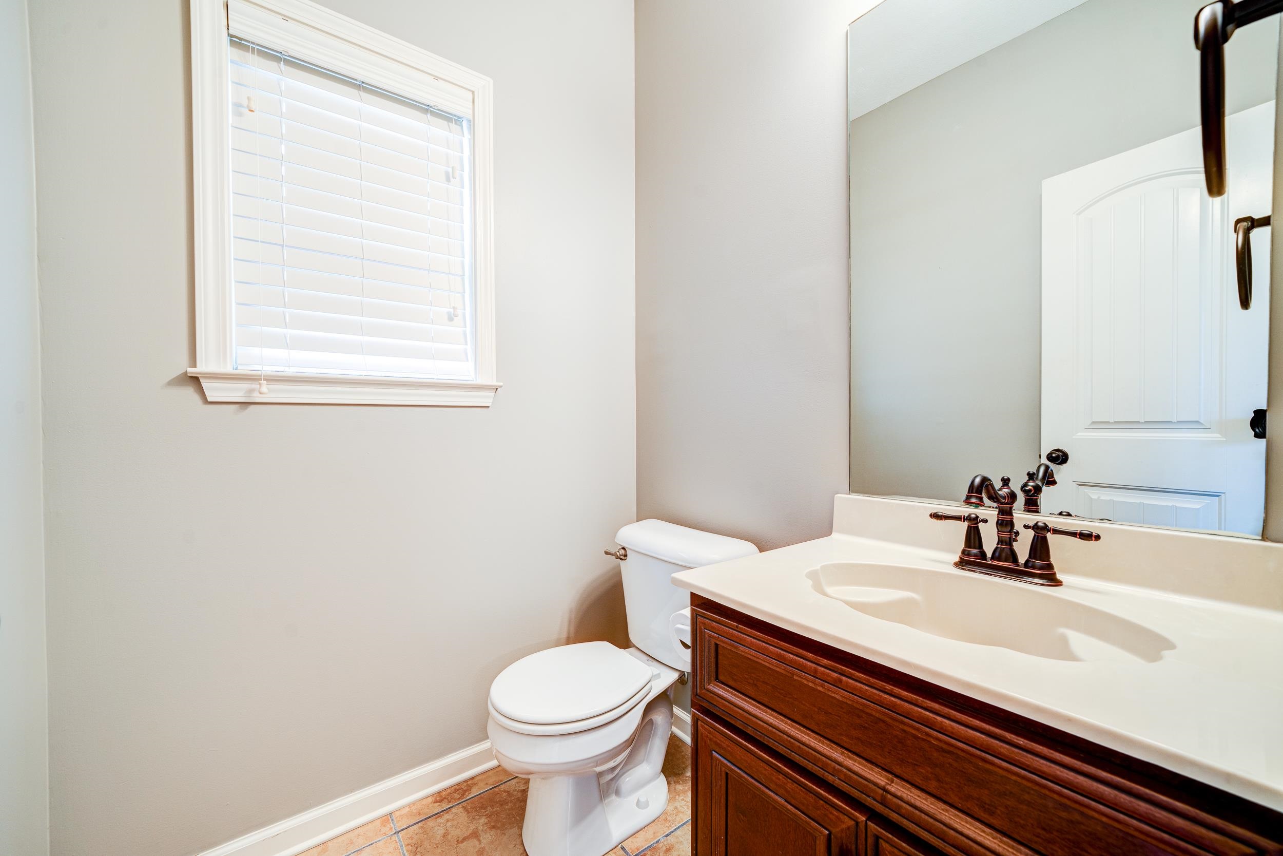 Bathroom with vanity, toilet, and tile patterned floors