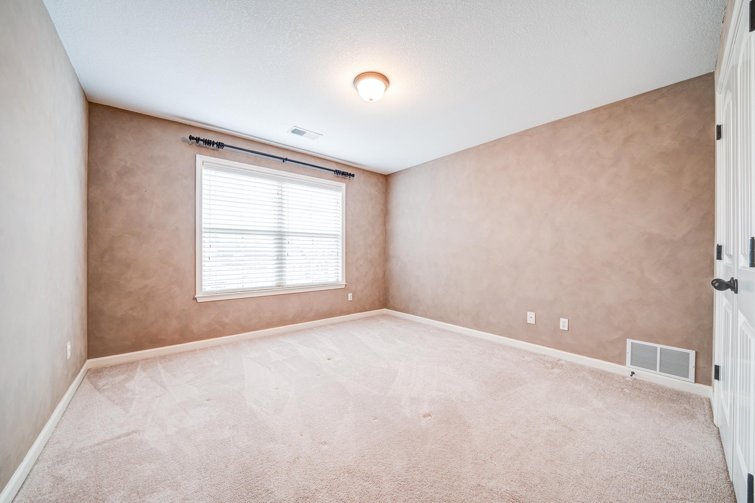 Carpeted empty room with a textured ceiling