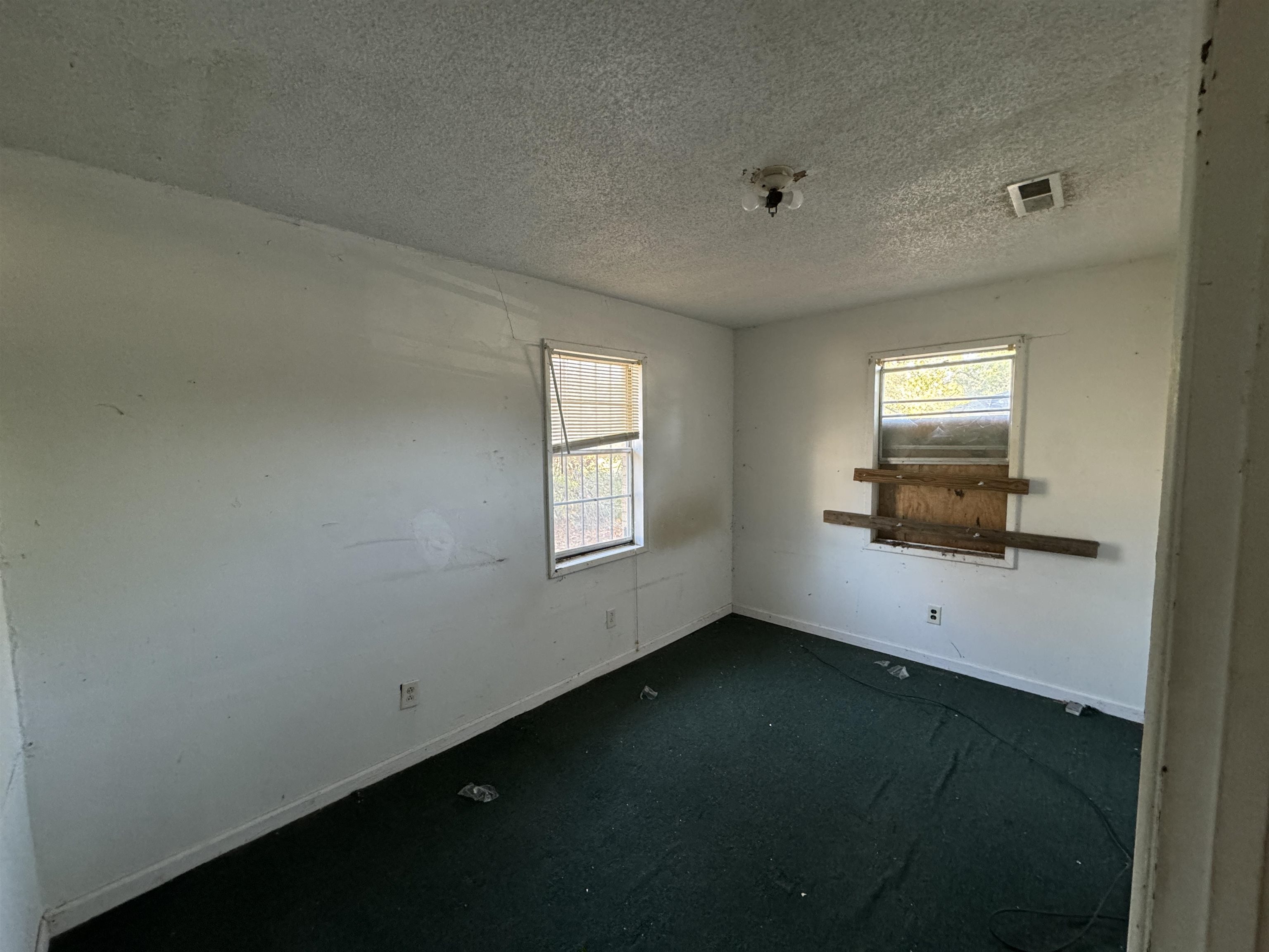 Carpeted spare room with a textured ceiling