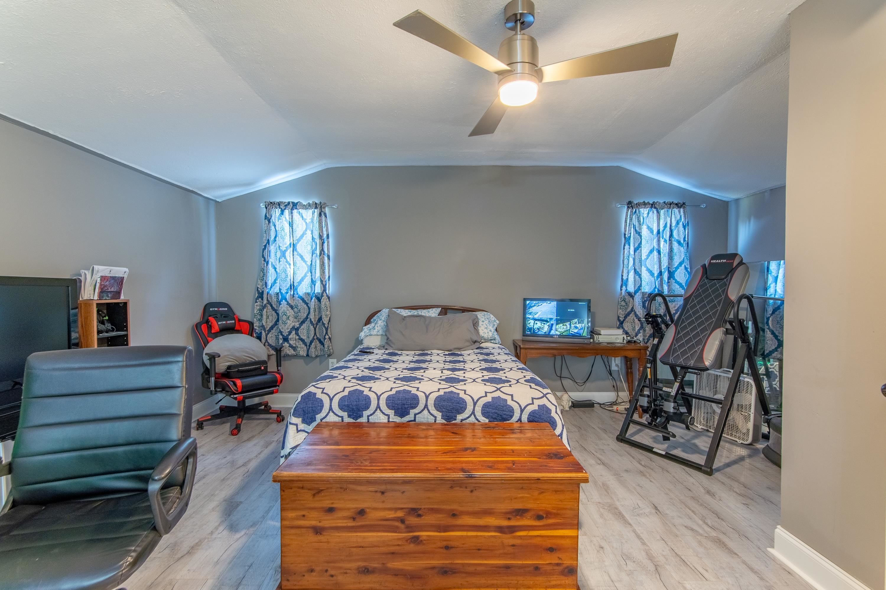 Bedroom featuring light hardwood / wood-style flooring, multiple windows, and ceiling fan