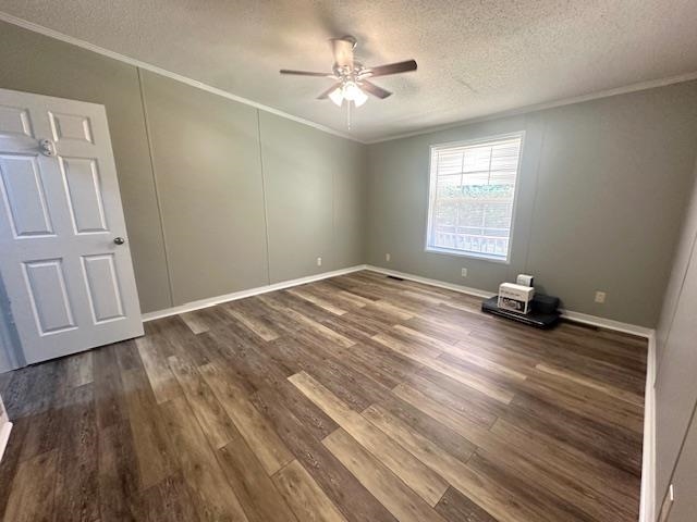 Empty room featuring ornamental molding, dark wood-type flooring, a textured ceiling, and ceiling fan