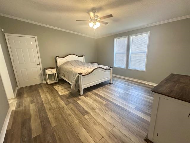 Bedroom with crown molding, wood-type flooring, a textured ceiling, and ceiling fan