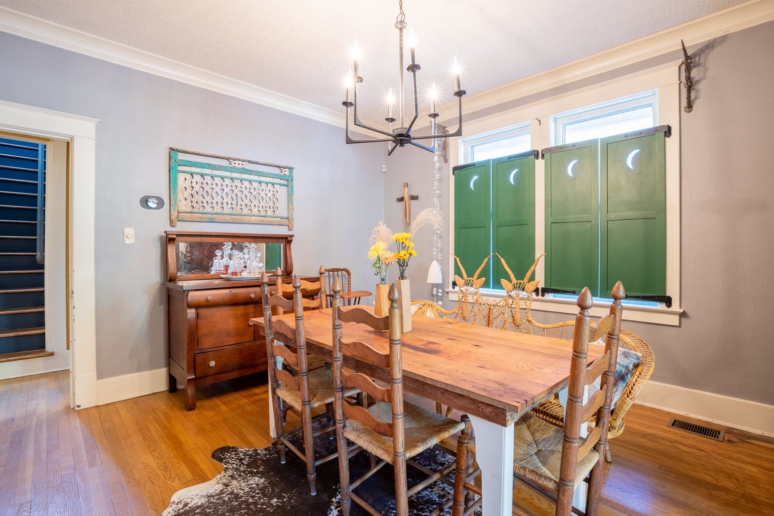 Dining room featuring an inviting chandelier, ornamental molding, and artsy shutters