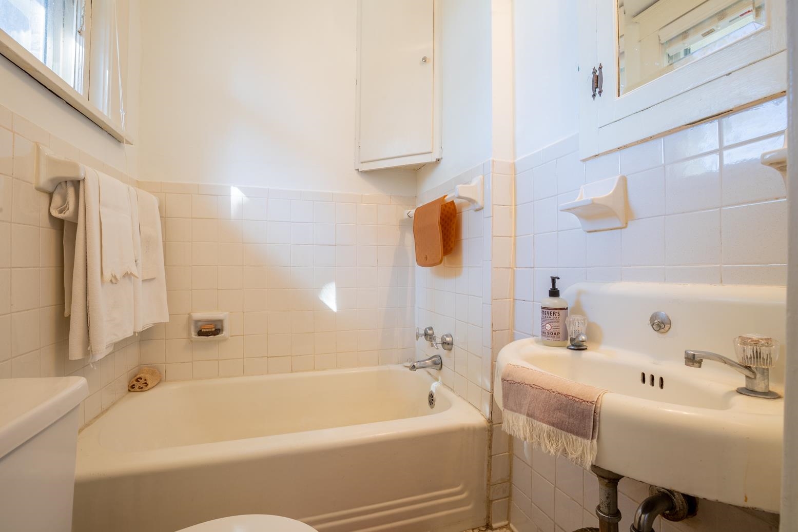 Bathroom with toilet, tile walls, and a tub on first floor