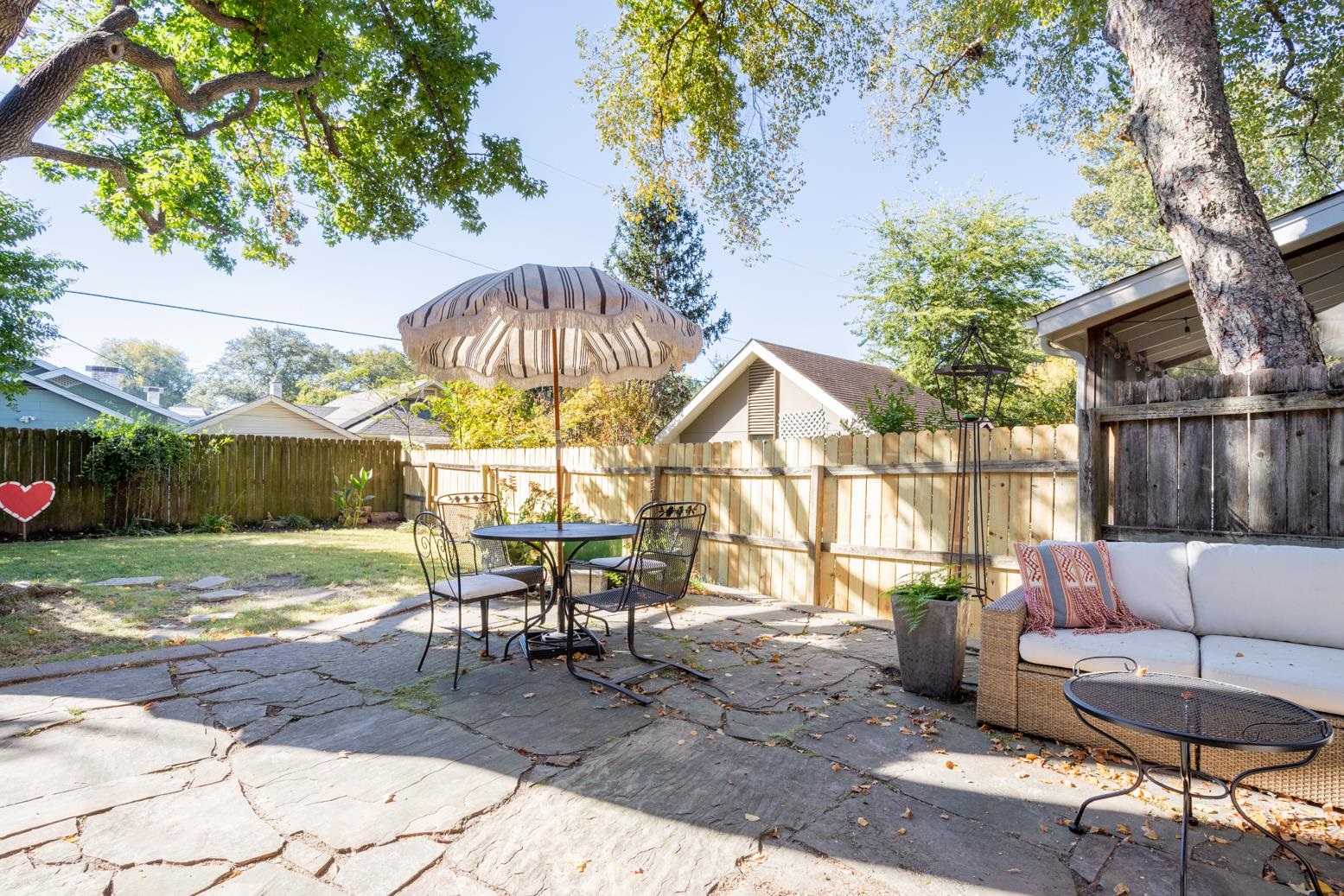 View of patio featuring outdoor lounge area, table/umbrella and new wood fencing down west side
