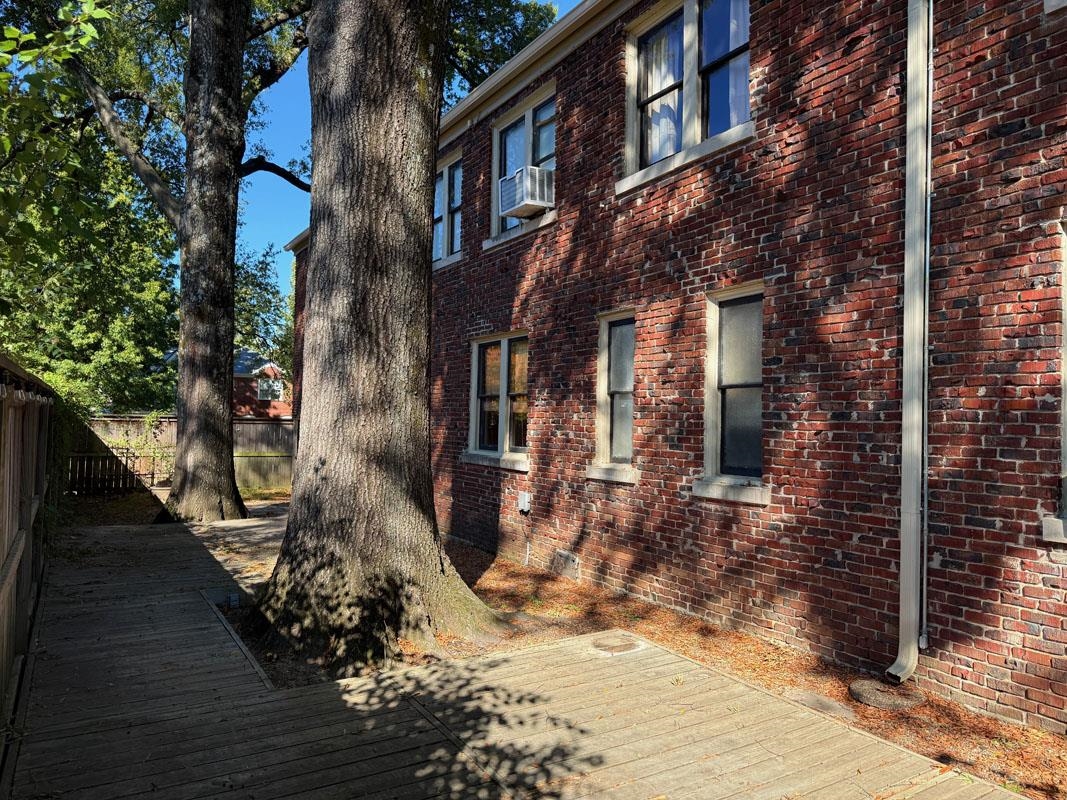 View of property exterior with a wooden deck and cooling unit