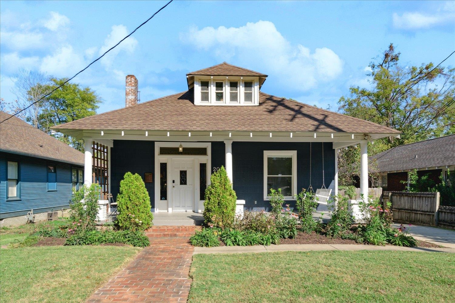 View of front of home featuring covered porch and a front yard