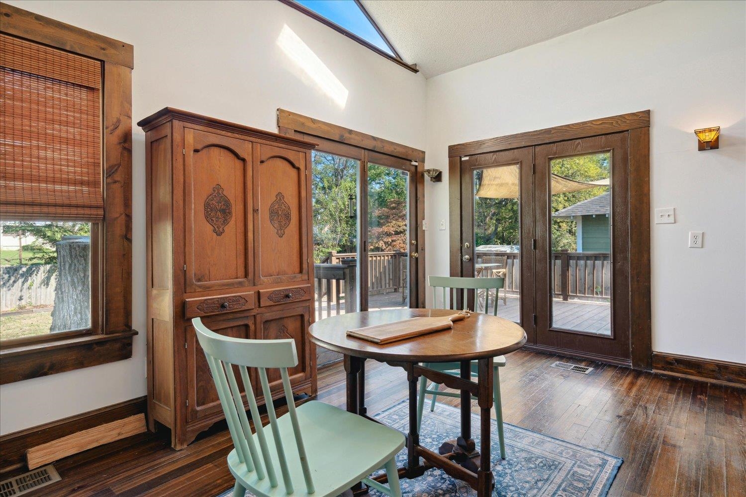 Dining room with lofted ceiling, dark hardwood / wood-style floors, a healthy amount of sunlight, and a textured ceiling