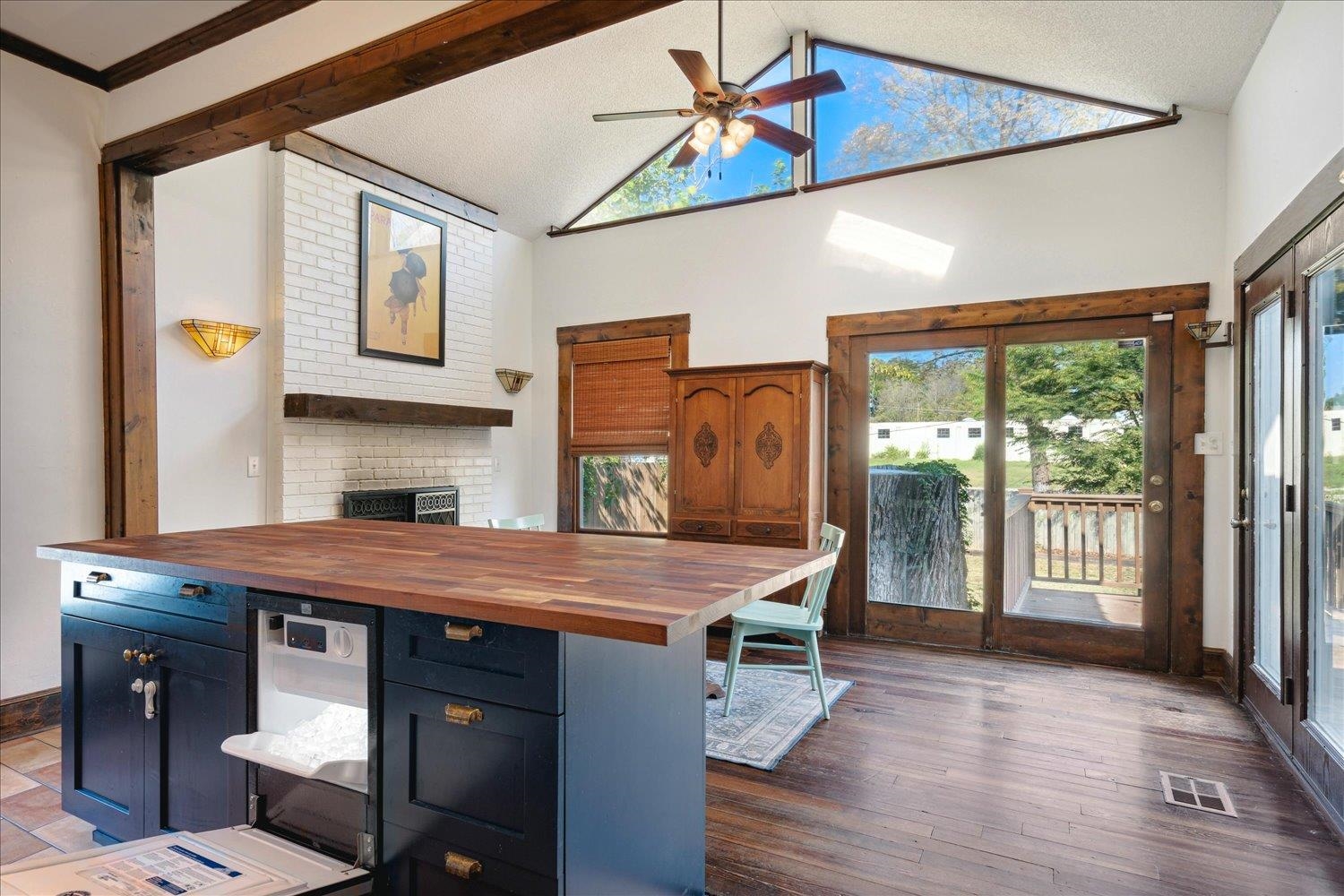Kitchen with dark wood-type flooring, ornamental molding, blue cabinetry, butcher block countertops, and ceiling fan