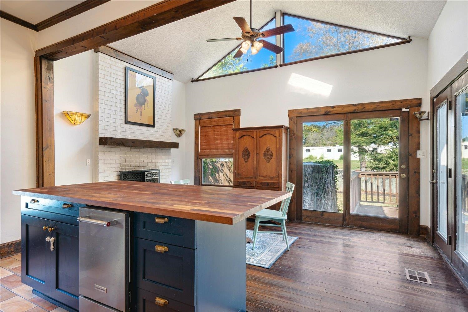 Kitchen featuring ceiling fan, blue cabinetry, dark hardwood / wood-style floors, butcher block counters, and crown molding