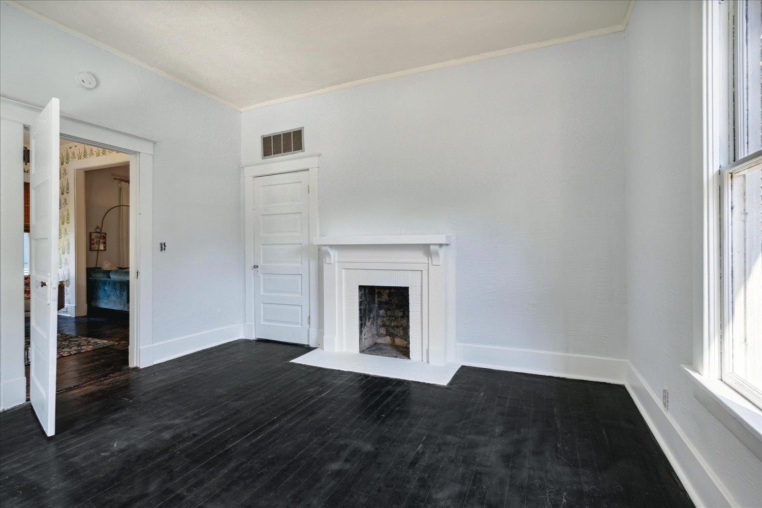 Unfurnished living room with ornamental molding and dark hardwood / wood-style flooring