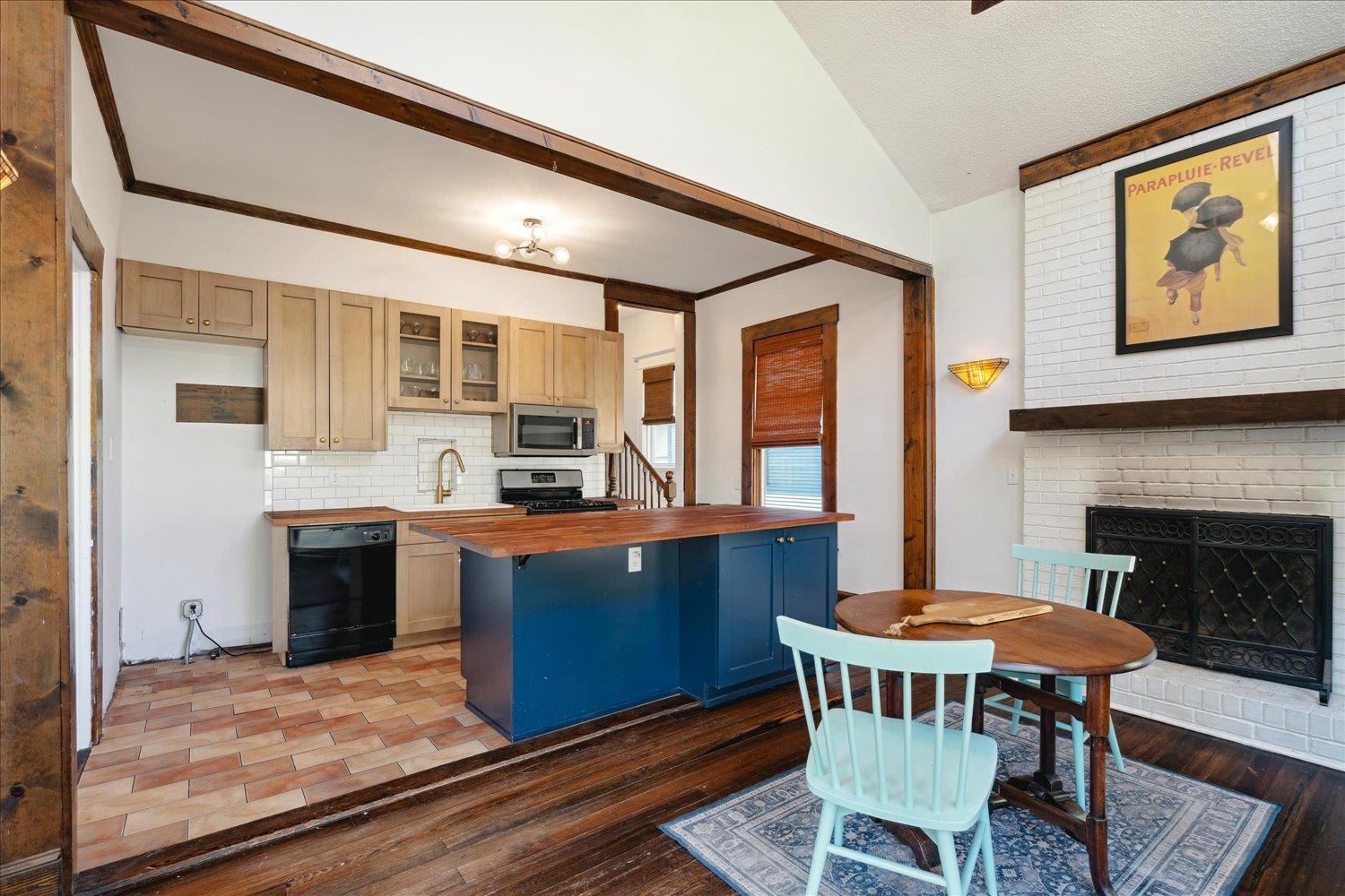 Kitchen featuring a kitchen bar, lofted ceiling, stove, wooden counters, and dark wood-type flooring. Brand new refrigerator being installed this week!
