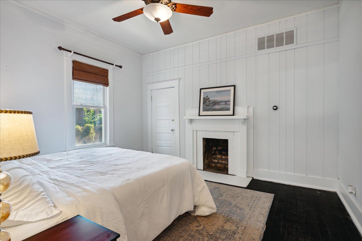 Bedroom with a closet, wooden walls, and ceiling fan