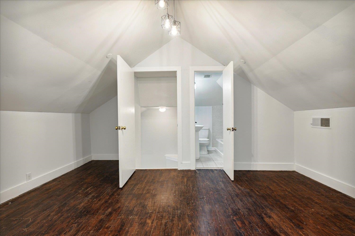 Additional living space featuring lofted ceiling and dark hardwood / wood-style flooring