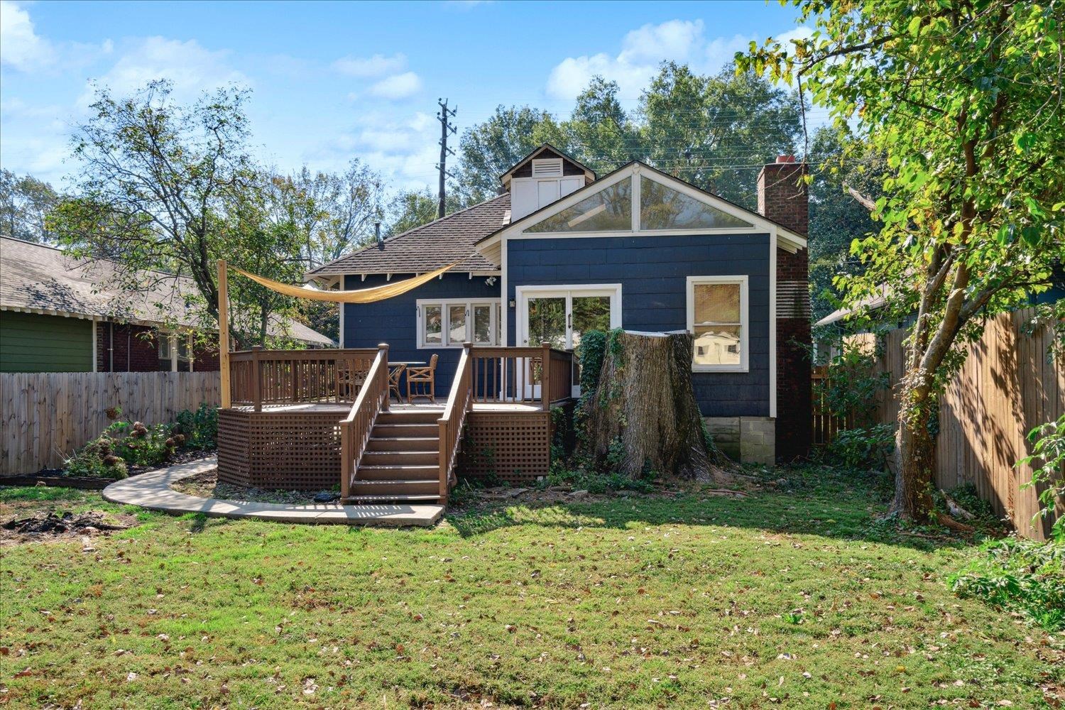 Back of property featuring a yard and a wooden deck