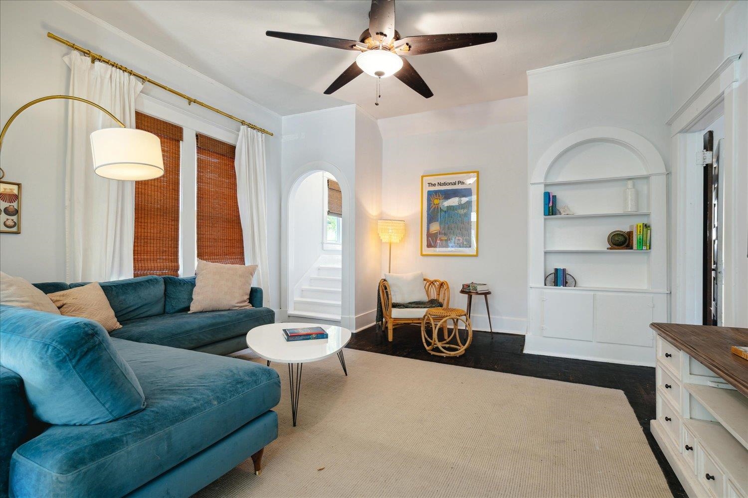 Living room featuring ceiling fan, built in features, and dark hardwood / wood-style flooring