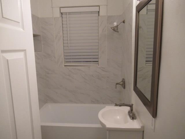 Bathroom featuring vanity and tiled shower / bath combo