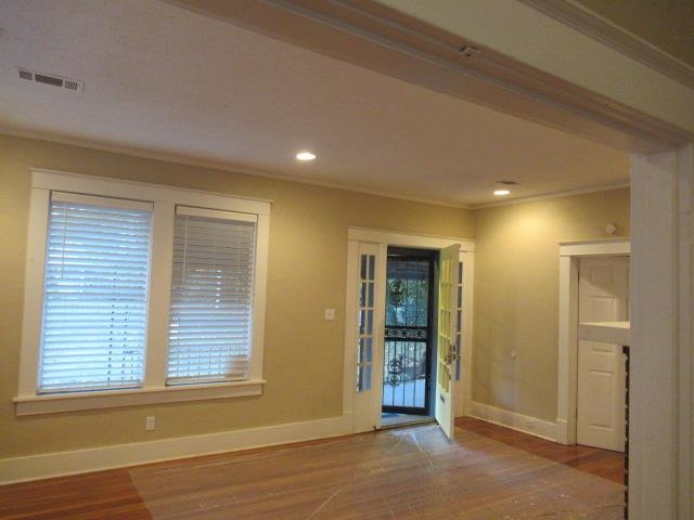 Doorway featuring crown molding and wood-type flooring