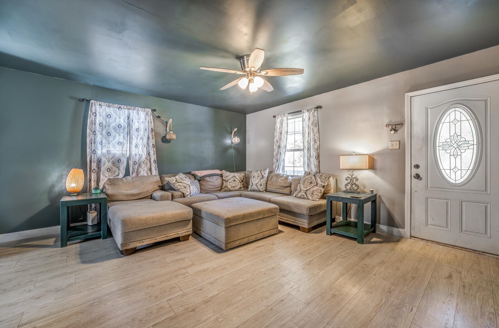 Living room with light wood-type flooring and ceiling fan