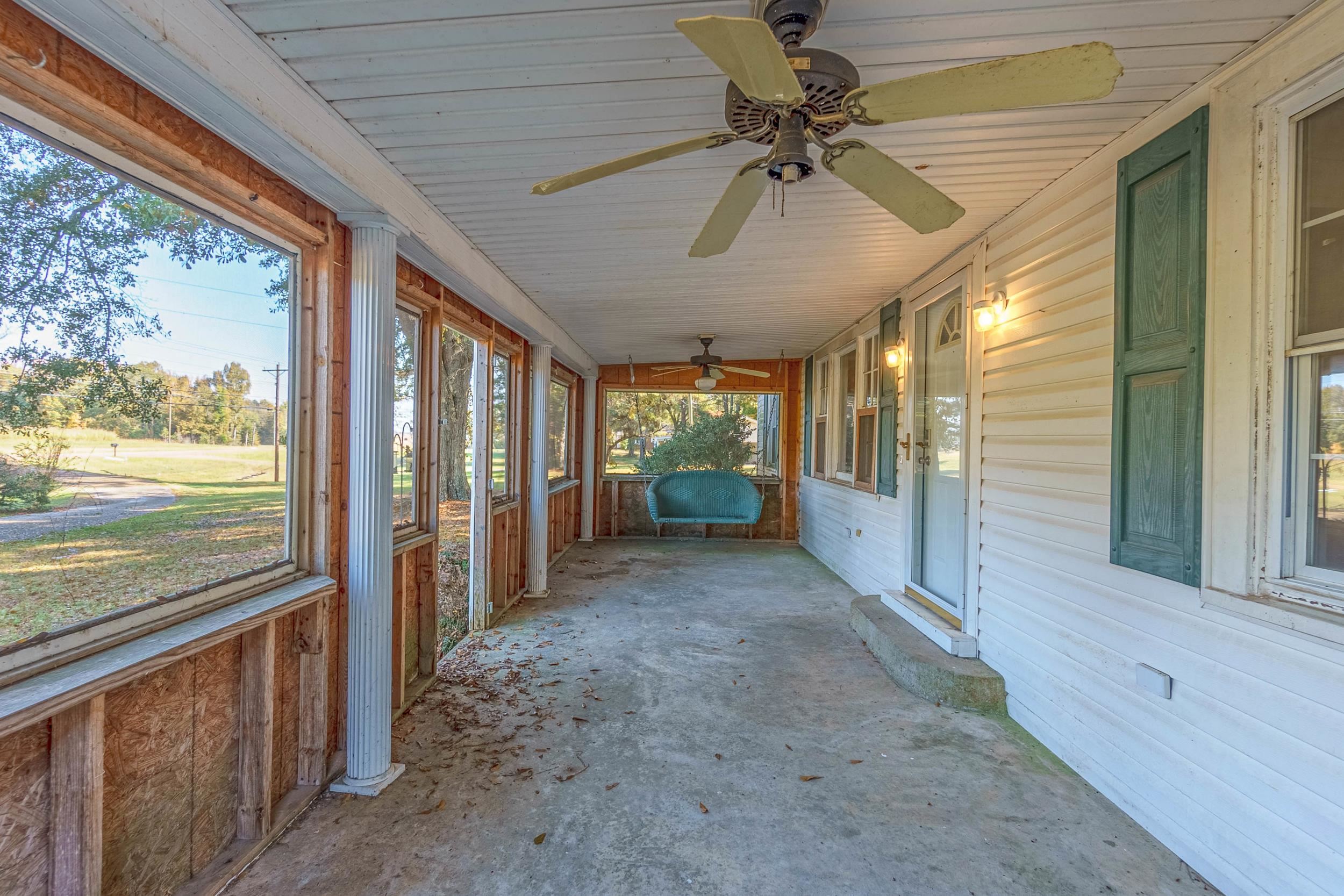 Unfurnished sunroom featuring ceiling fan