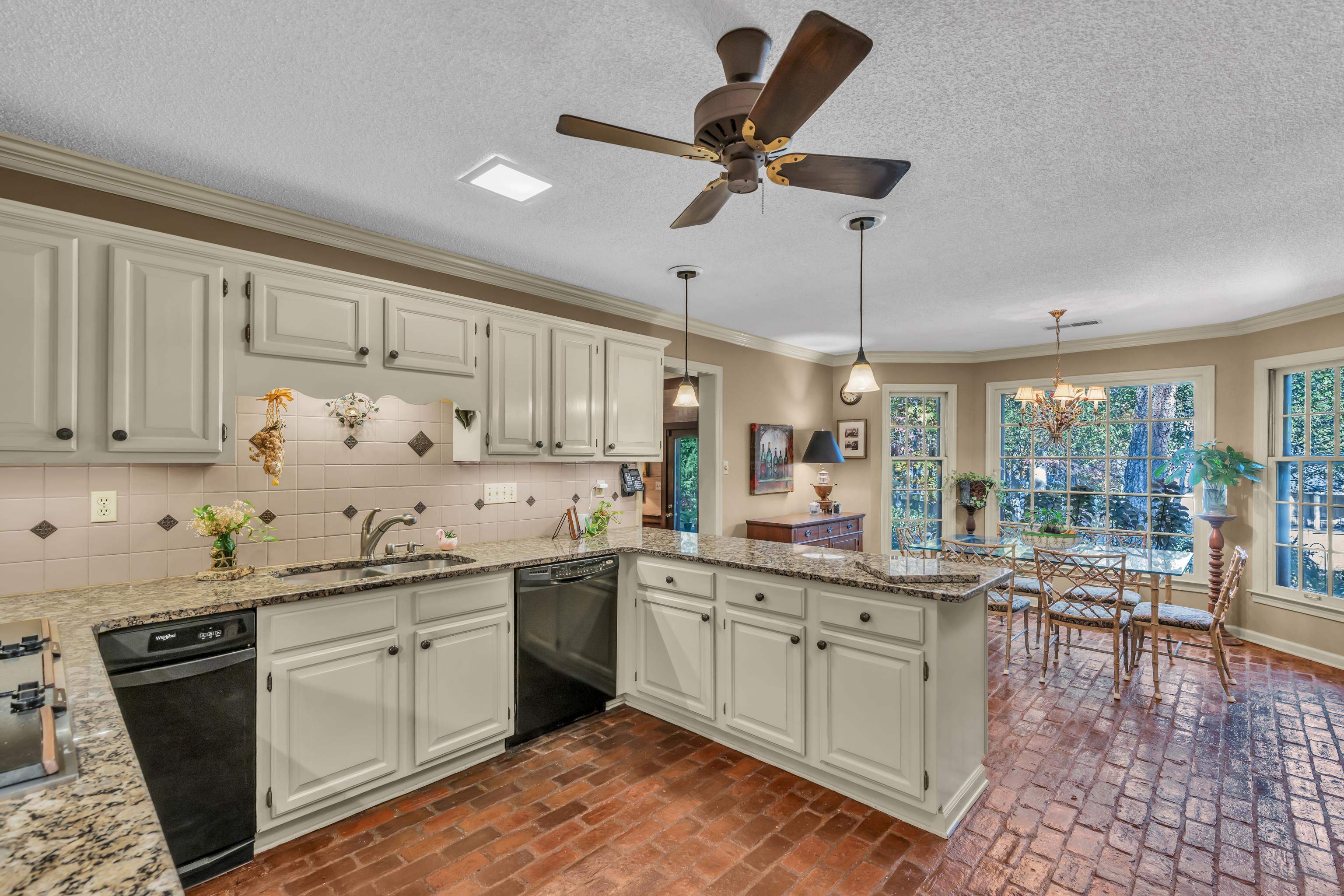 Kitchen with black dishwasher, kitchen peninsula, sink, and plenty of natural light