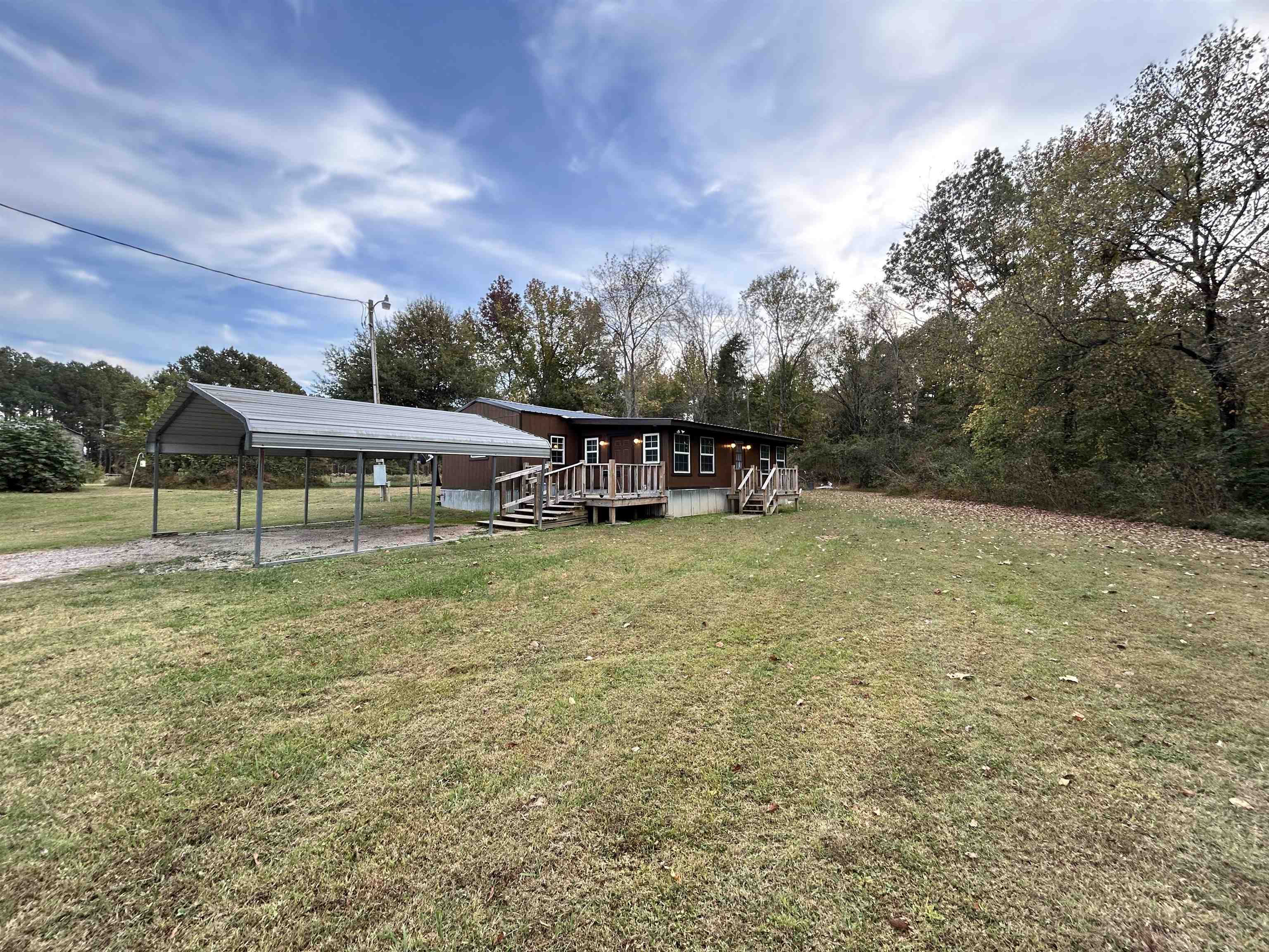 View of yard featuring a carport and a deck