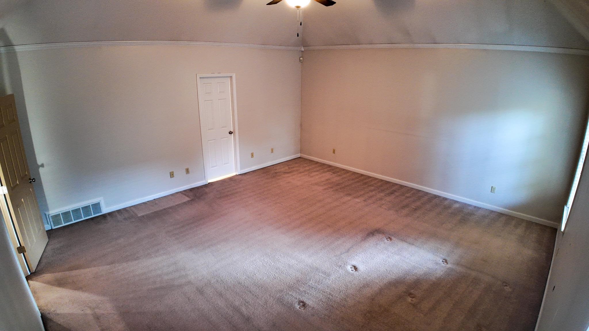 Interior space with ceiling fan, crown molding, lofted ceiling, and carpet floors