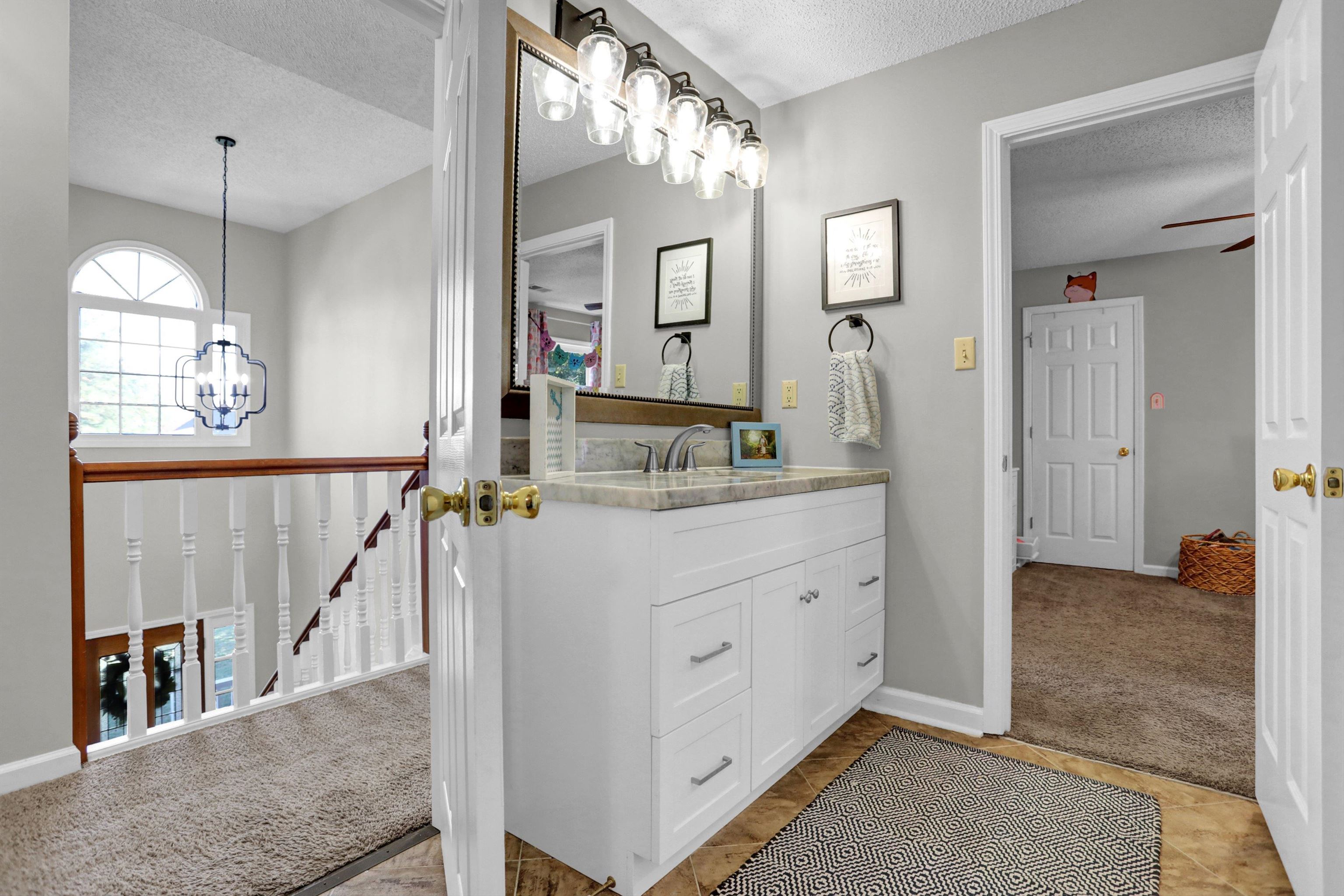 Bathroom with vanity, a textured ceiling, and a chandelier