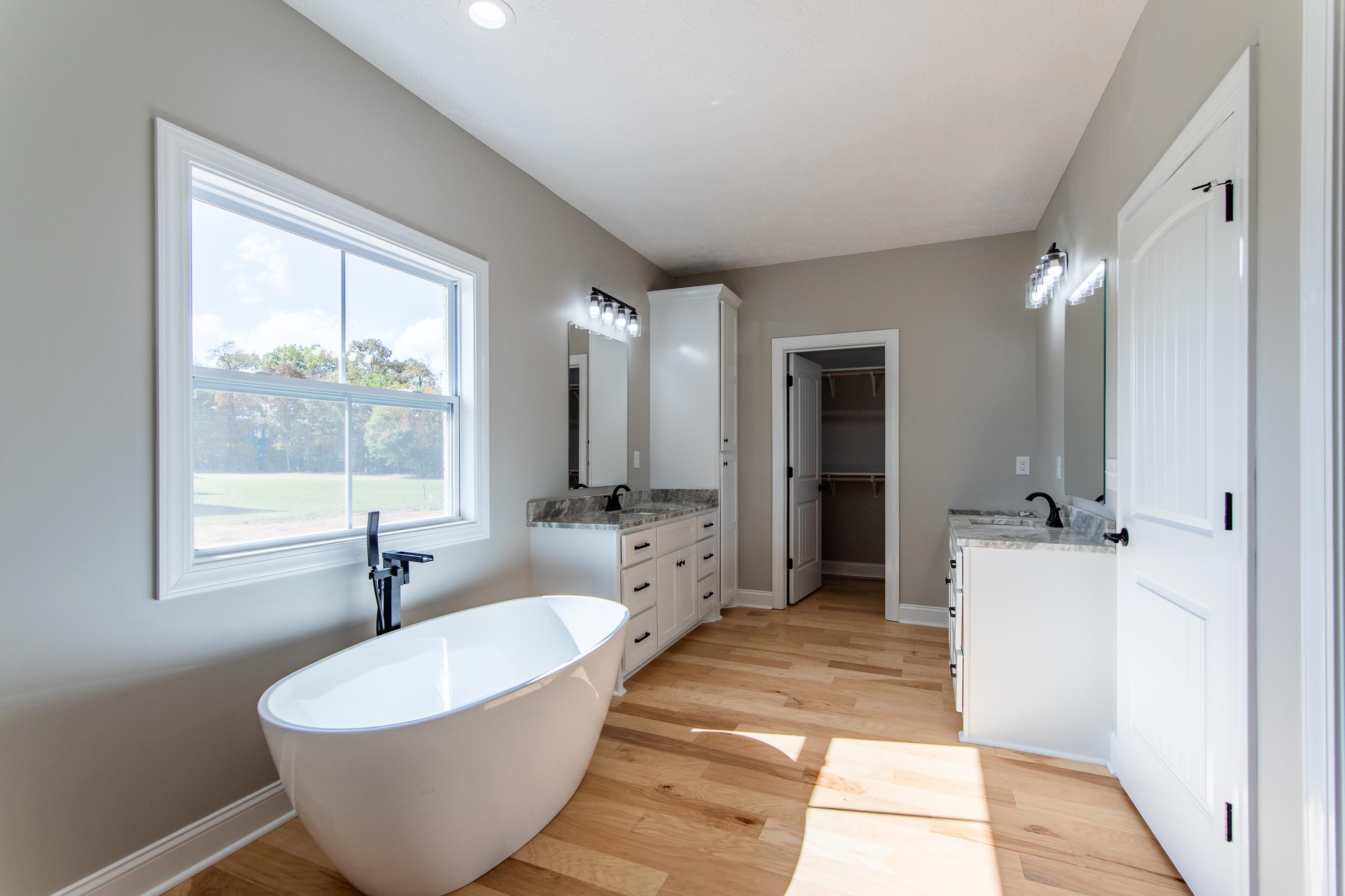 Bathroom with vanity, hardwood / wood-style floors, and a bath