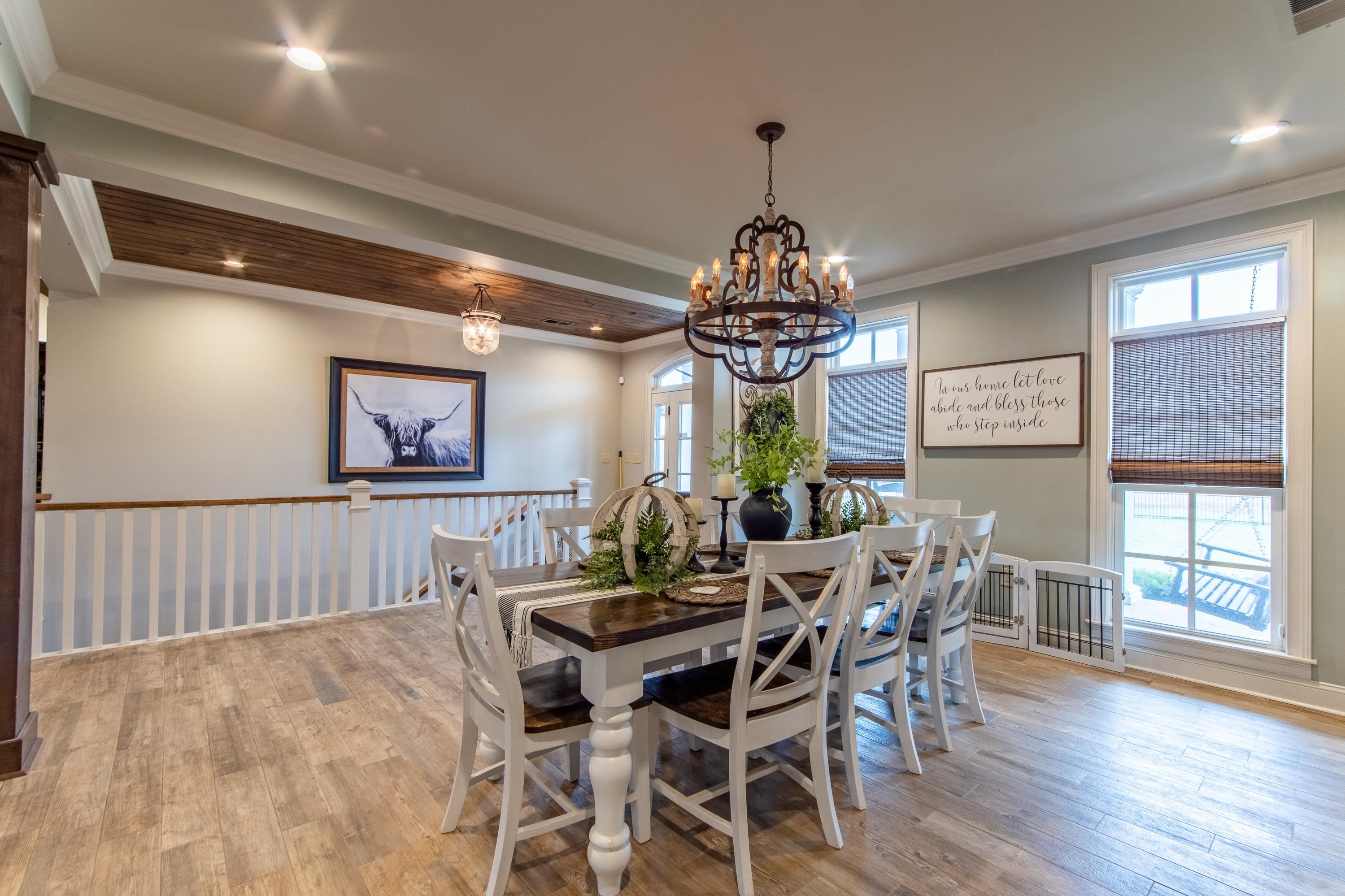 Dining area with an inviting chandelier, ornamental molding, and light wood-type flooring