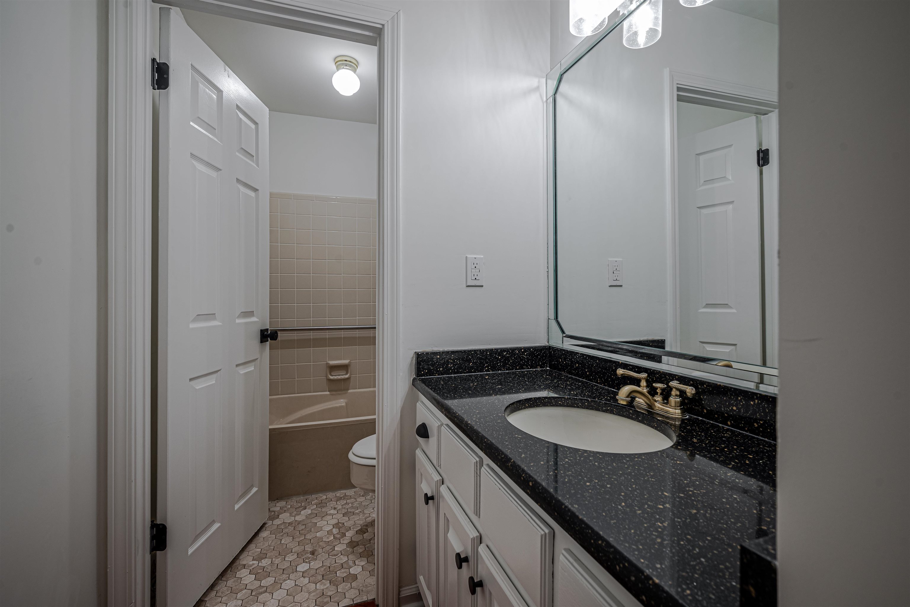 Bathroom featuring vanity, toilet, and tile patterned flooring