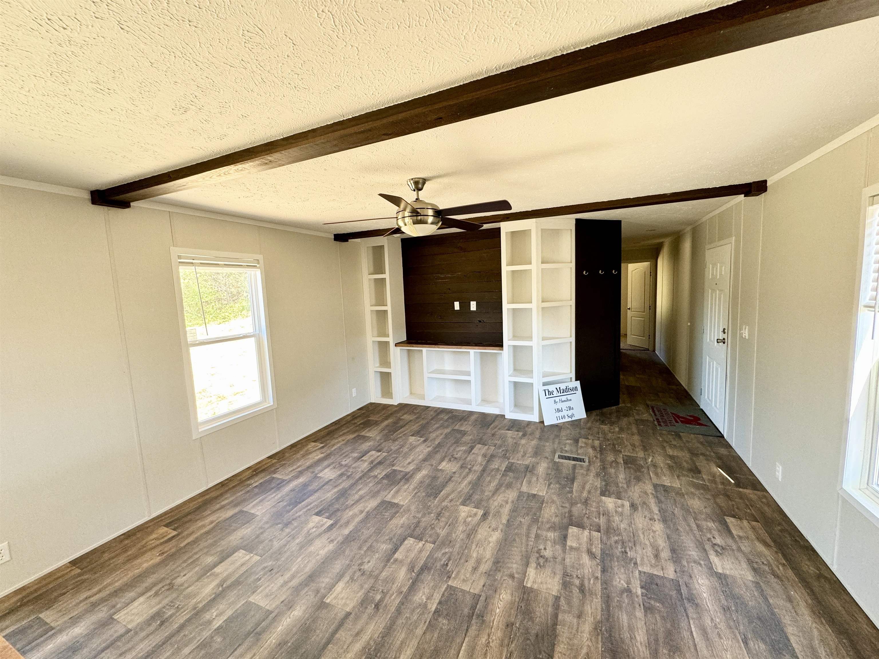 Interior space with beam ceiling, dark wood-type flooring, crown molding, and a textured ceiling