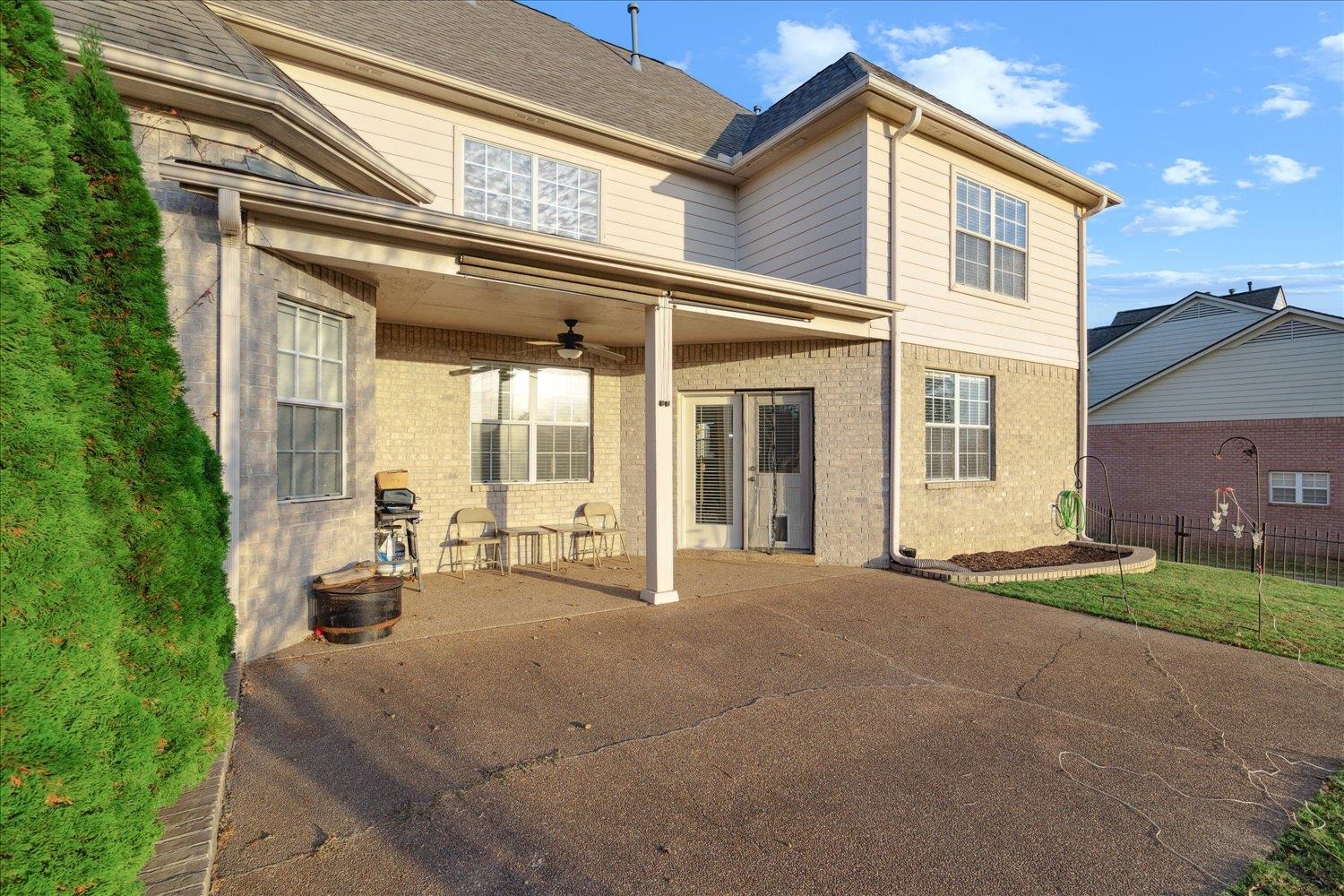 Rear view of property with a patio, a lawn, and ceiling fan