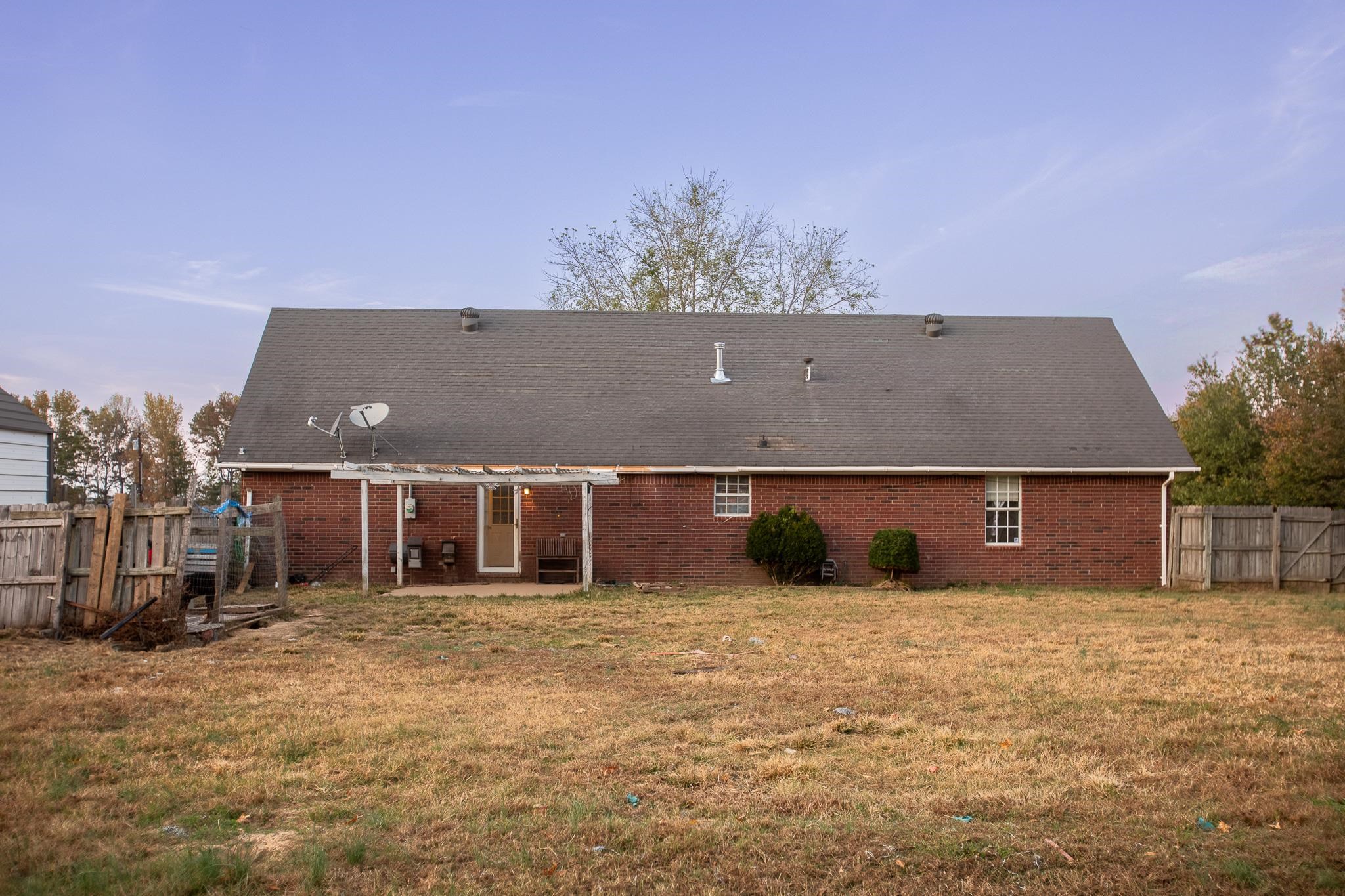 Rear view of house featuring a patio area, a yard, and a pergola