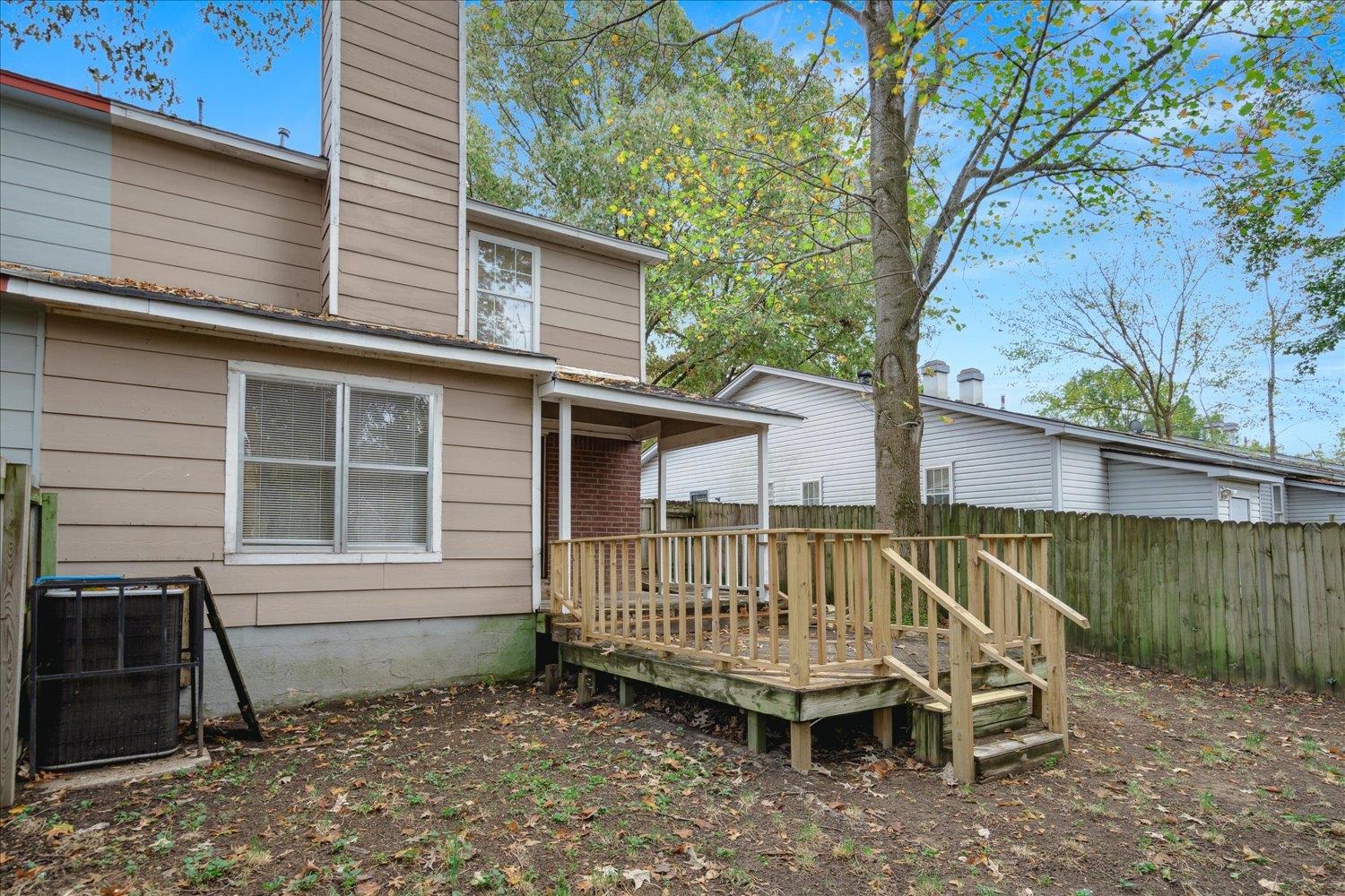 Back of house with a wooden deck and central AC unit