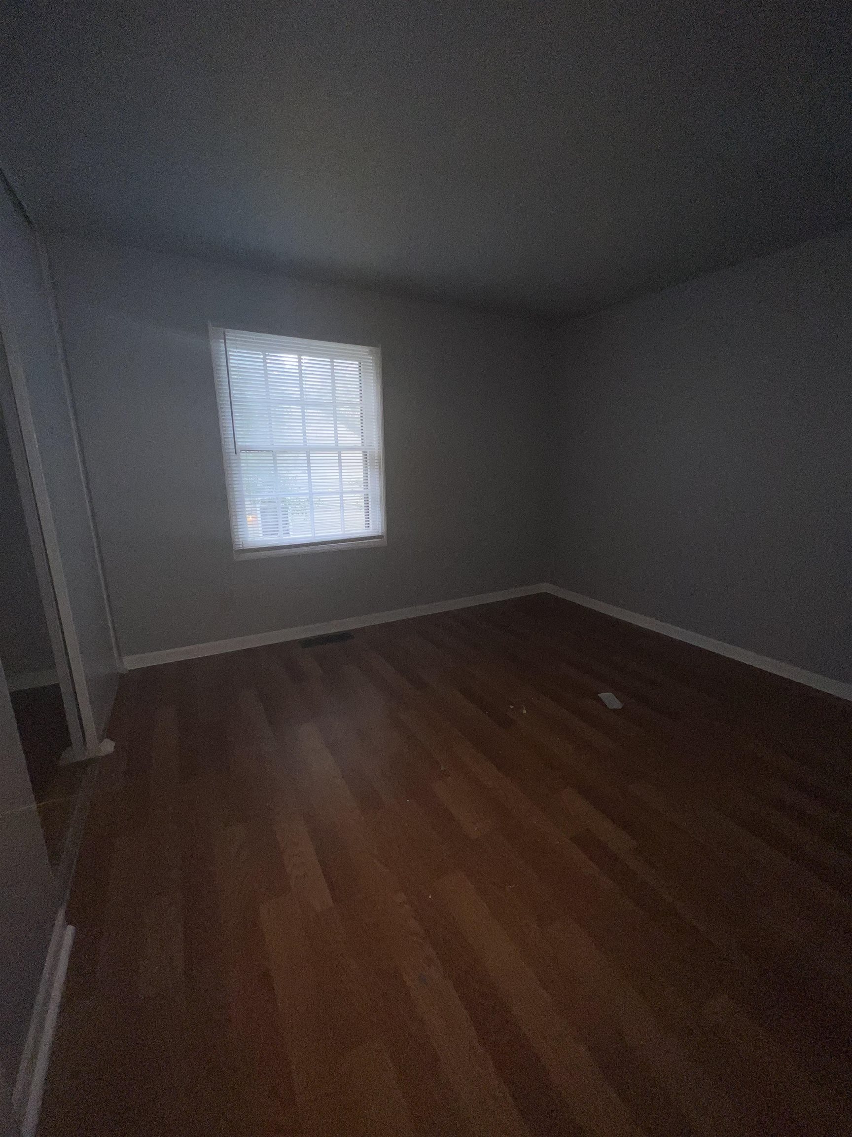 Empty room with dark hardwood / wood-style floors