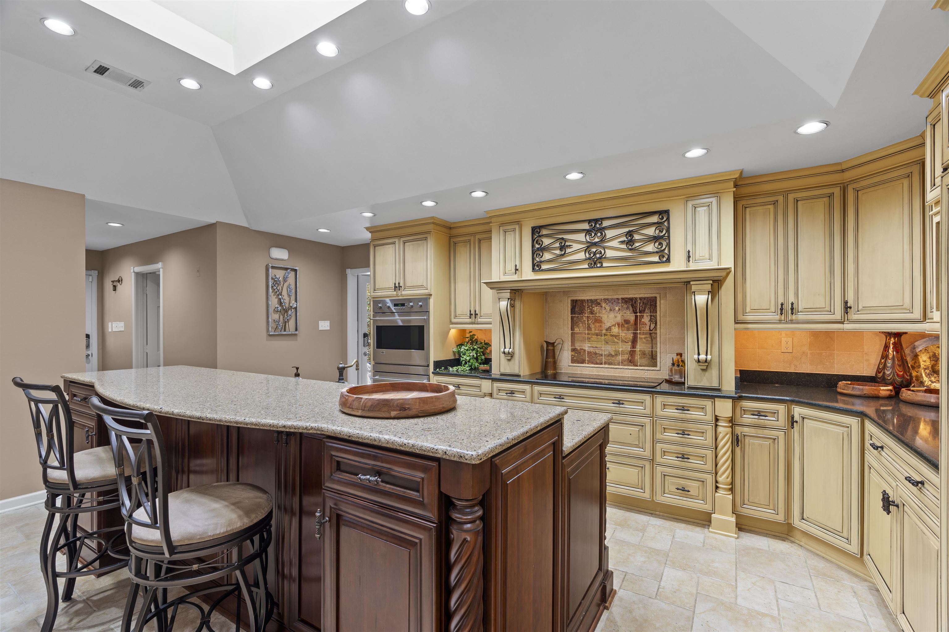 Kitchen with under cabinet lighting, pull-out spice racks, and custom moldings and glazing.