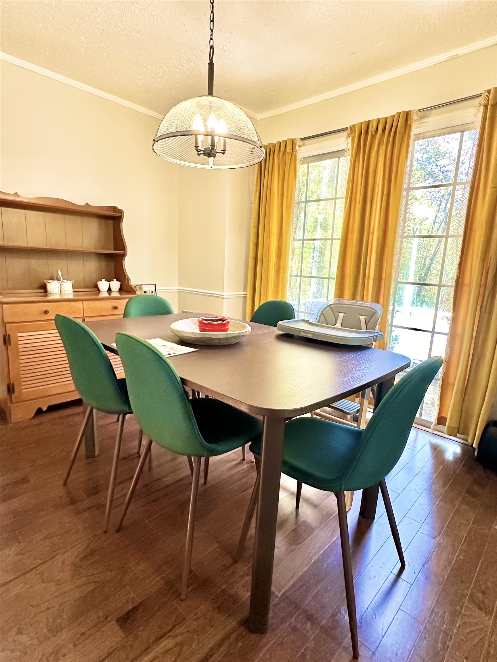 Dining room with ornamental molding, a notable chandelier, a textured ceiling, and dark hardwood / wood-style flooring