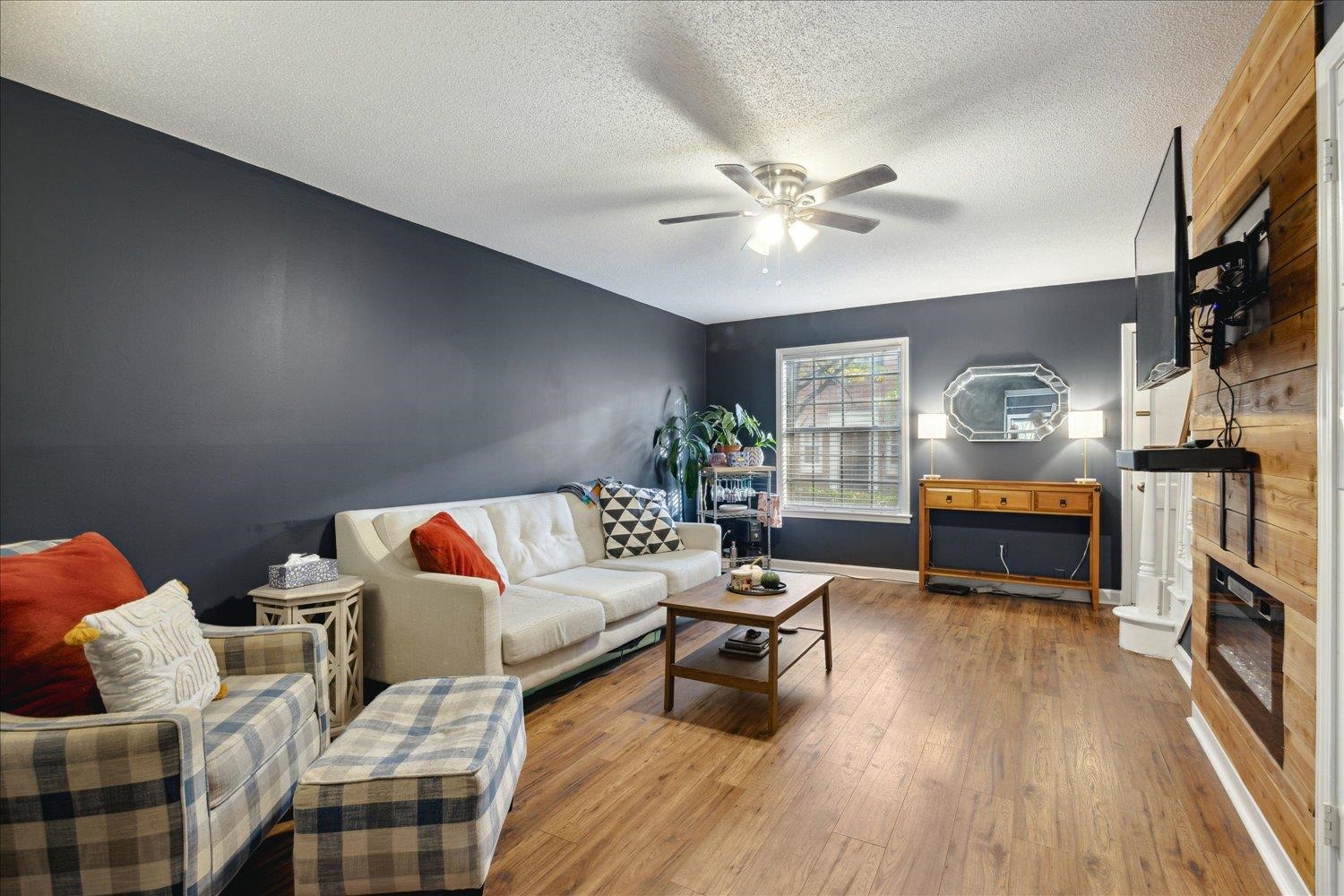 Living room featuring ceiling fan, a textured ceiling, and hardwood / wood-style floors