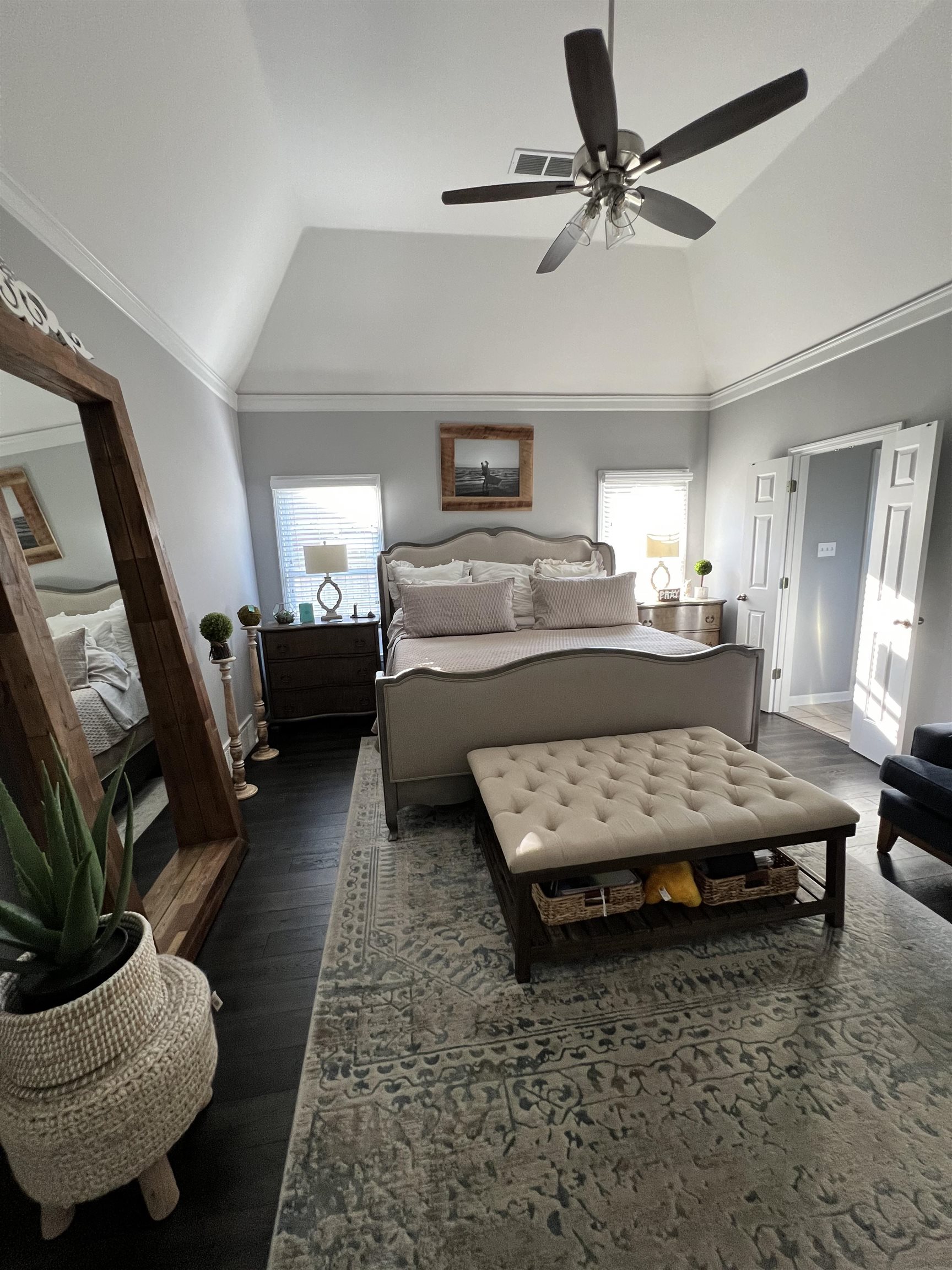 Bedroom with high vaulted ceiling, dark hardwood / wood-style flooring, ceiling fan, and crown molding