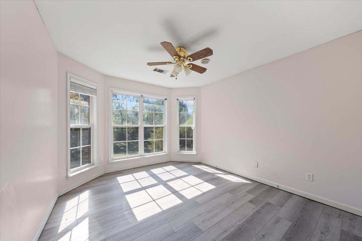 Empty room featuring light wood-type flooring and ceiling fan