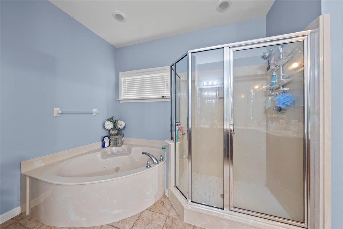 Bathroom featuring tile patterned floors and separate shower and tub