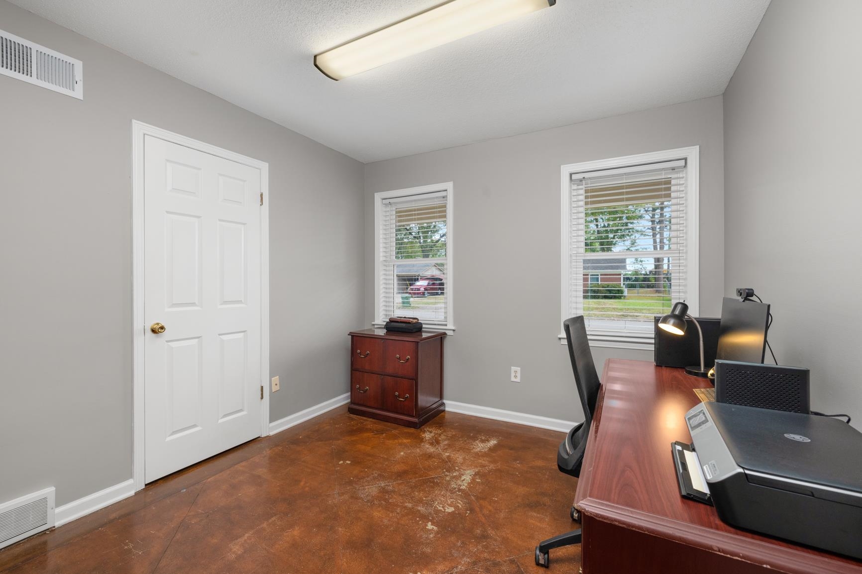 Bedroom 3 featuring a healthy amount of sunlight and a textured ceiling. Scored Concrete Floors