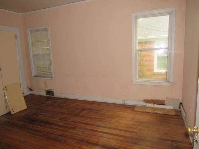 Unfurnished room featuring a wealth of natural light and dark hardwood / wood-style floors