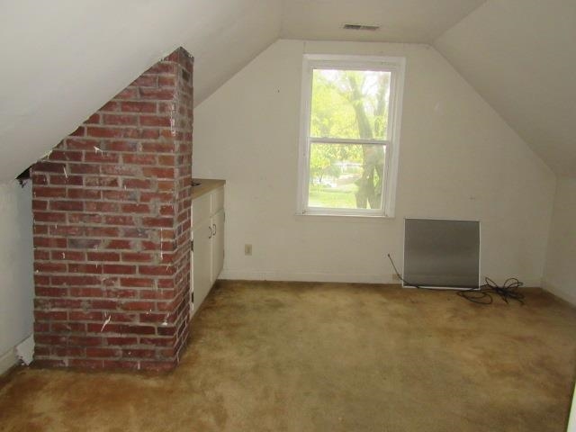 Additional living space with carpet flooring and lofted ceiling
