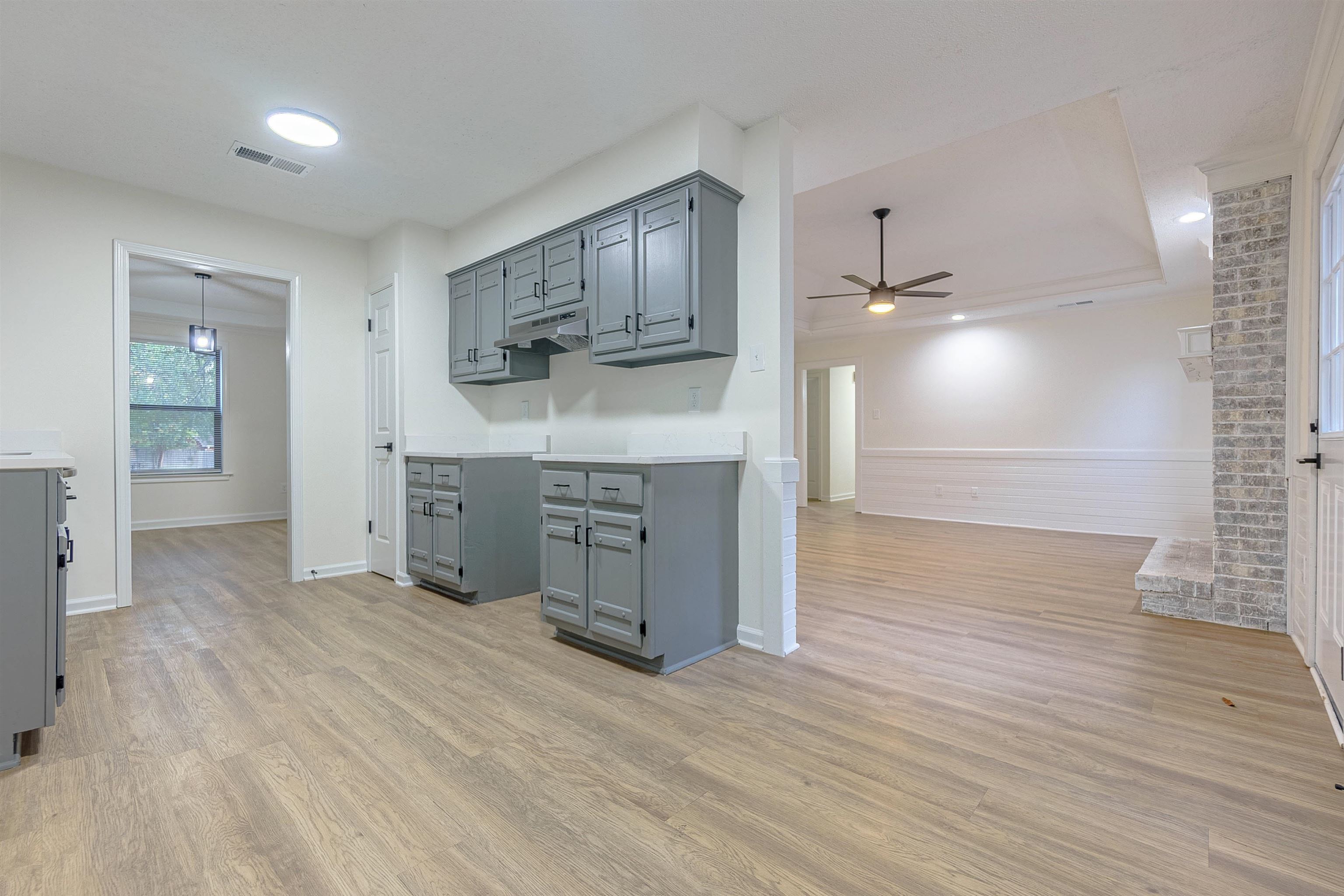 Kitchen featuring gray cabinetry, light wood-type flooring, and ceiling fan