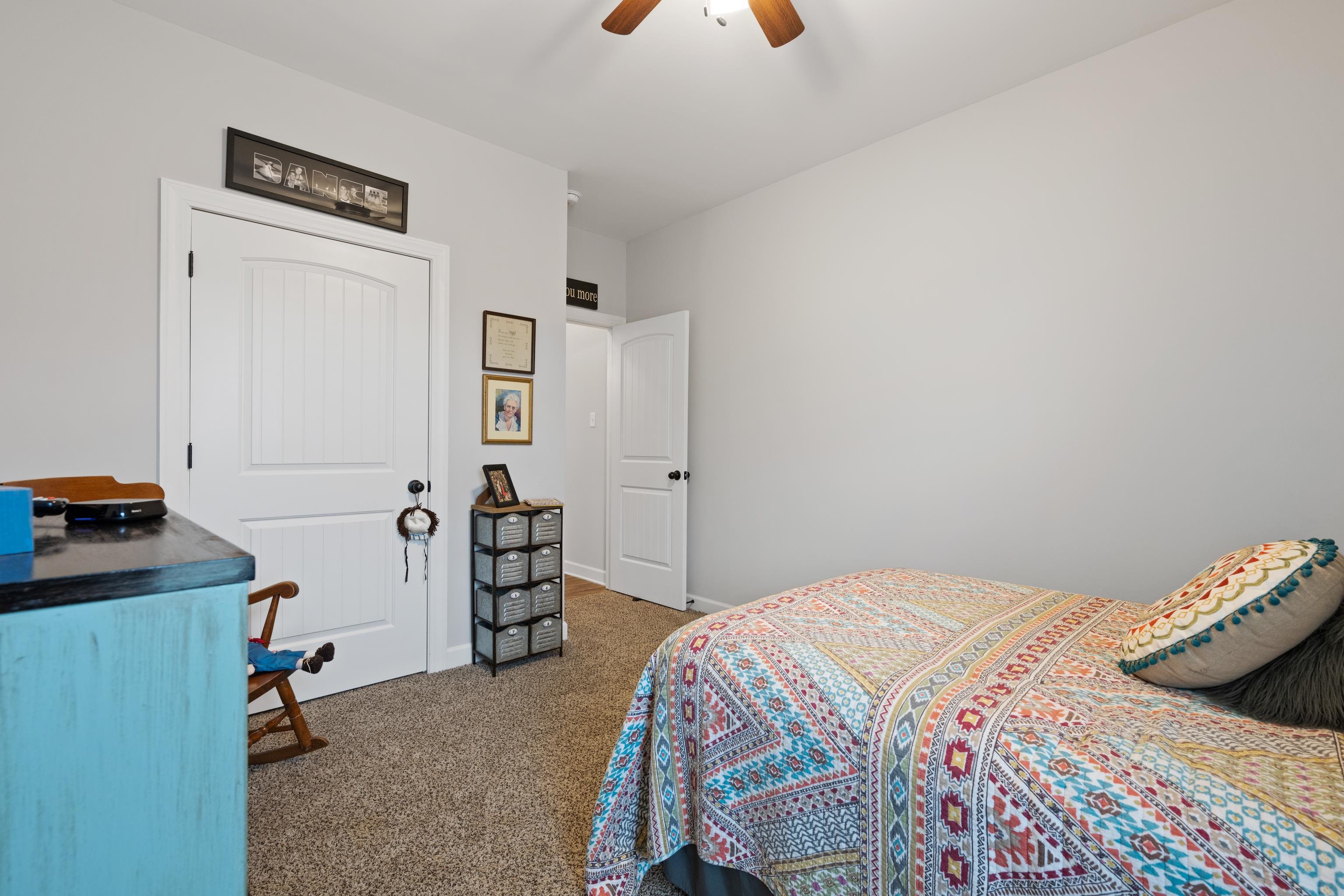 Carpeted bedroom featuring ceiling fan