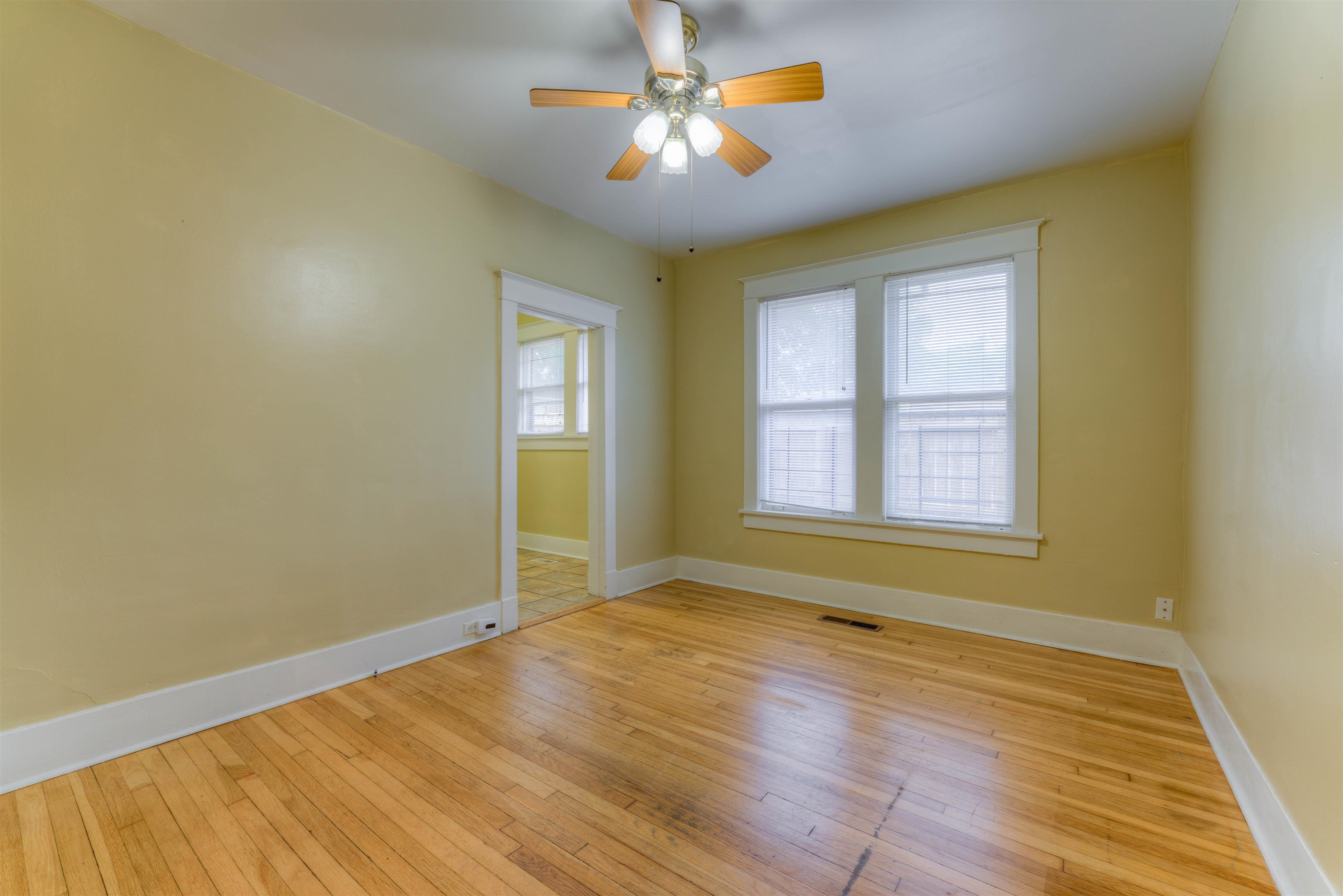 Empty room with ceiling fan and light hardwood / wood-style floors