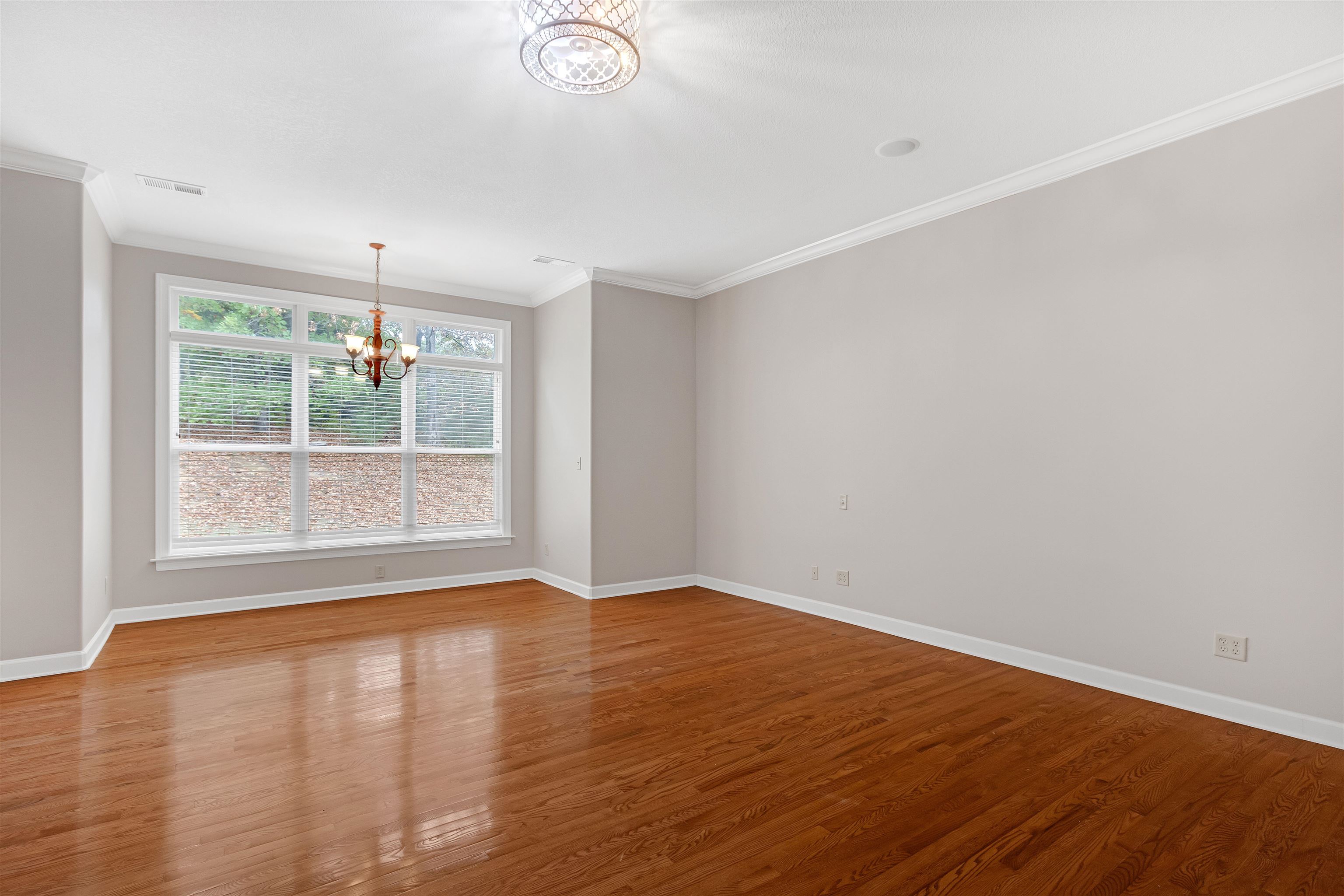 Unfurnished room with a chandelier, hardwood / wood-style flooring, and ornamental molding